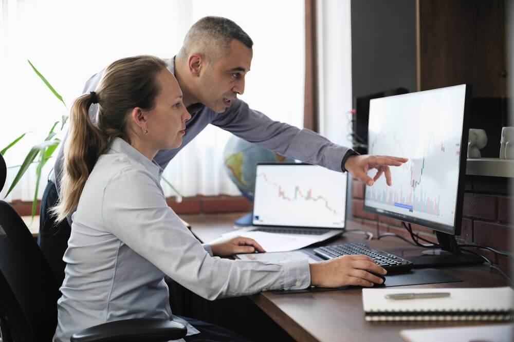 Professional woman in glasses using a tablet in a modern, softly lit office.